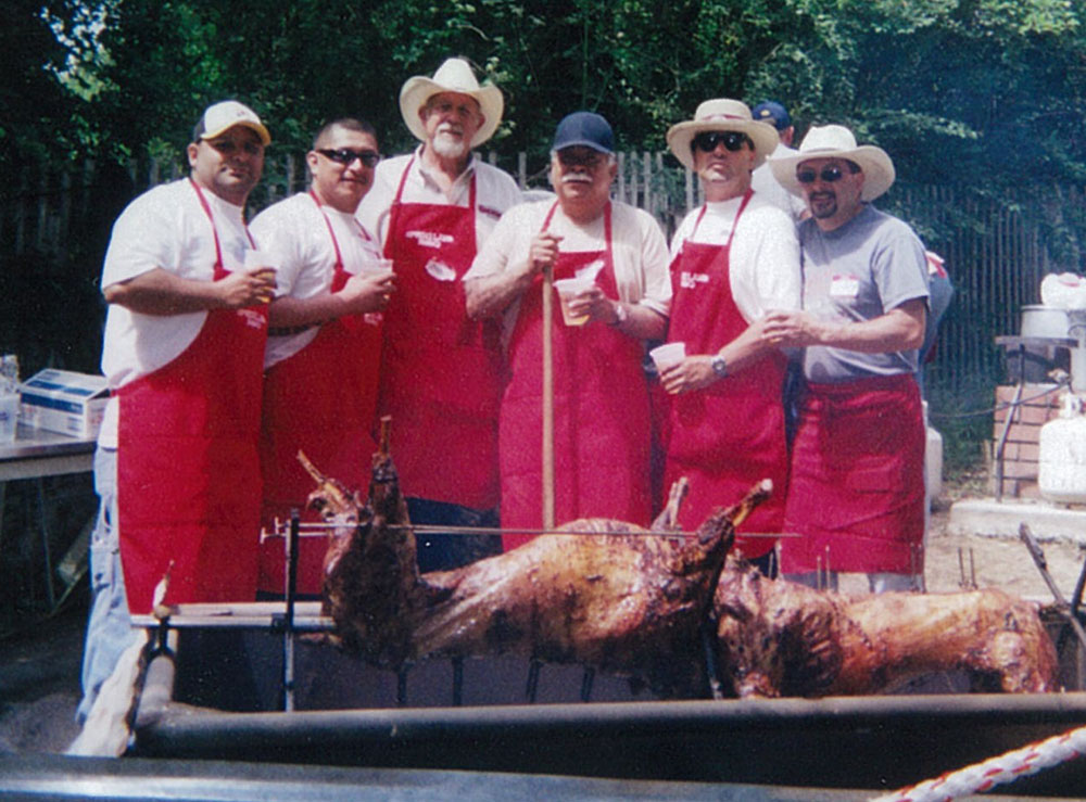 group of men barbequing a lamb